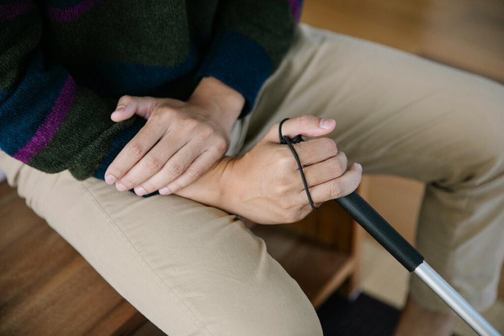 A detailed close-up of hands holding a walking stick, conveying support and care.